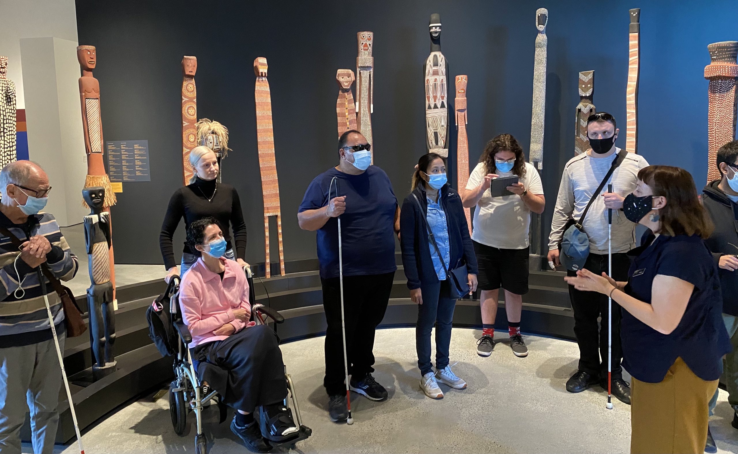 small group of clients holding white canes at an art gallery