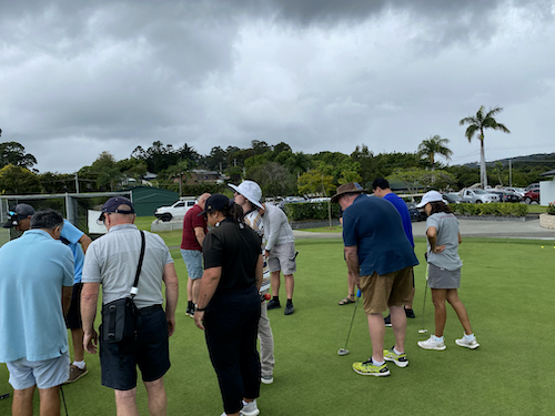 Group of 12 people on the golf green at a social event