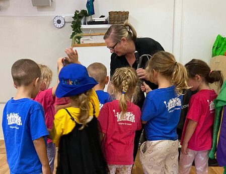 Lisa surrounded by lots of kindi aged children